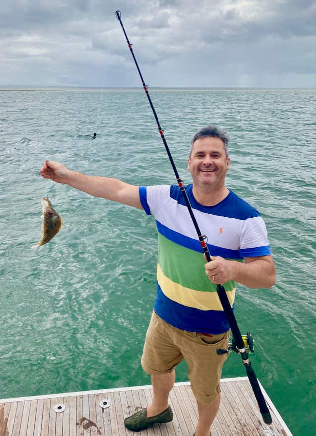 Guest caught a fish at the Lazarette on sailing yacht Curlew Escape on a private yacht charter, Moreton Bay, Brisbane.