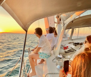 Friends on a sunset sail on a private yacht charter on Curlew Escape, Moreton Bay, Brisbane.