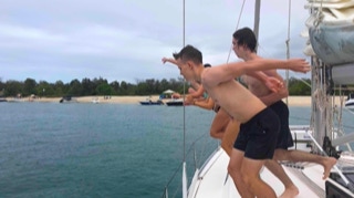 Leaping off the yacht  on  Sailing Yacht Curlew Escape, available for private yacht charters on Moreton Bay, Brisbane.