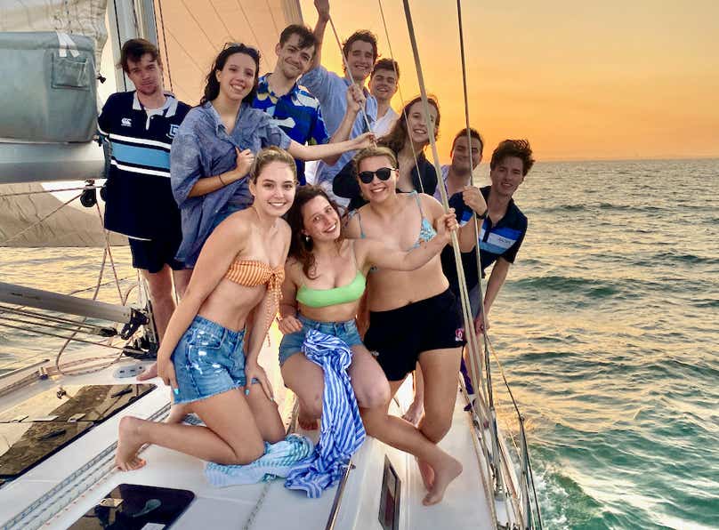 Friends enjoying lunch around the cockpit table while on a sailing charter in Moreton Bay.