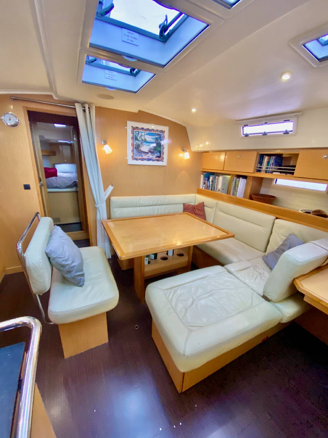 Saloon table with leather sofa and cushions available on the yacht on a private yacht charter, Moreton Bay.