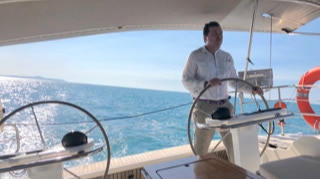 Skipper Greg at the helm  on  Sailing Yacht Curlew Escape, available for private yacht charters on Moreton Bay, Brisbane.