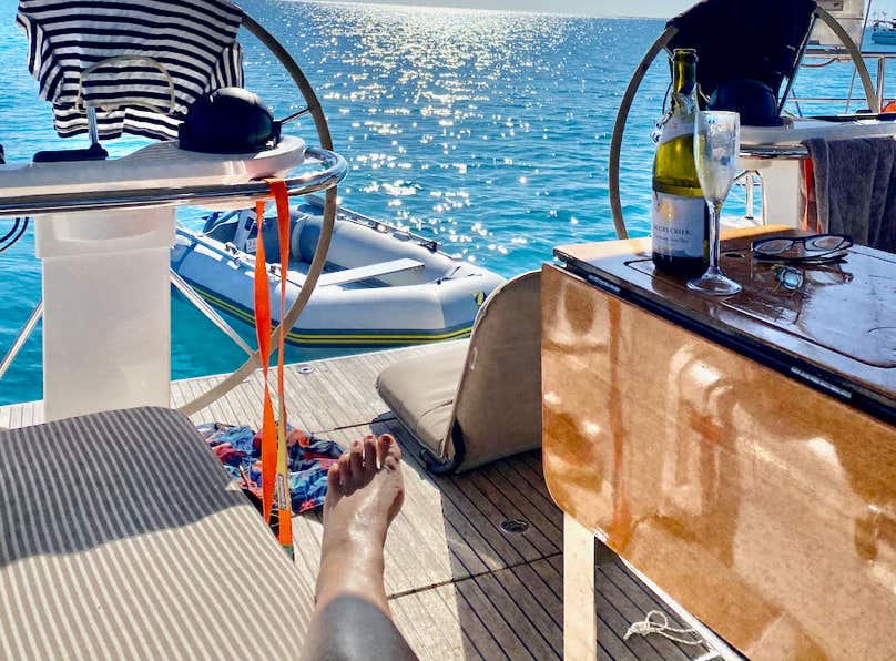 Friends enjoying lunch around the cockpit table while on a sailing charter in Moreton Bay.