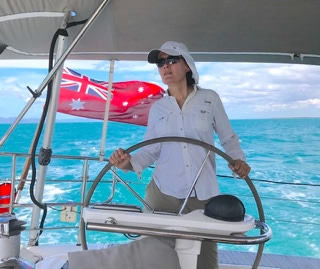 Wife at the helm on a private yacht charter on Curlew Escape, Moreton Bay, Brisbane.