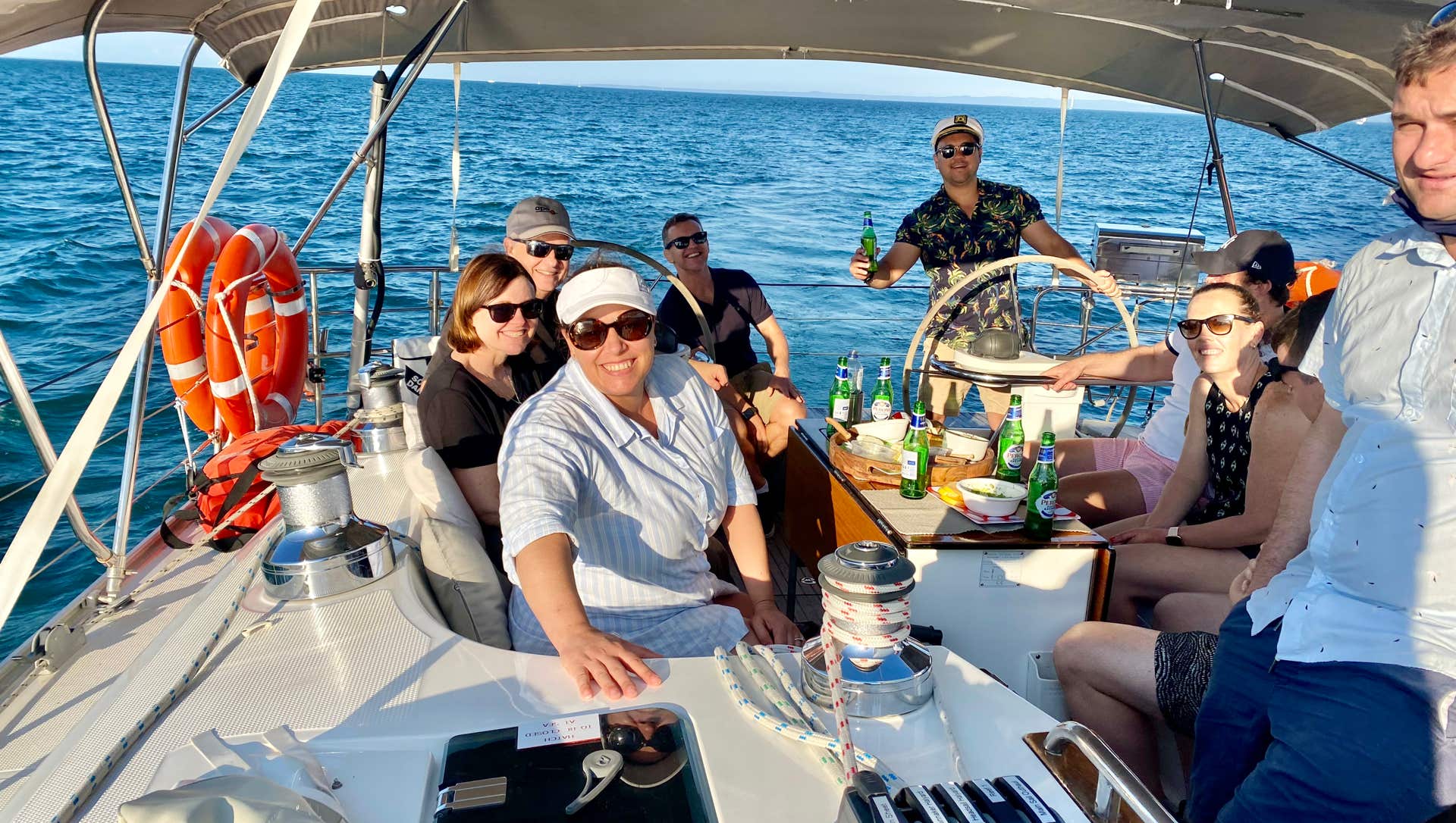Employees enjoying a social yacht race against another work team on a private yacht charter in Moreton Bay, Brisbane